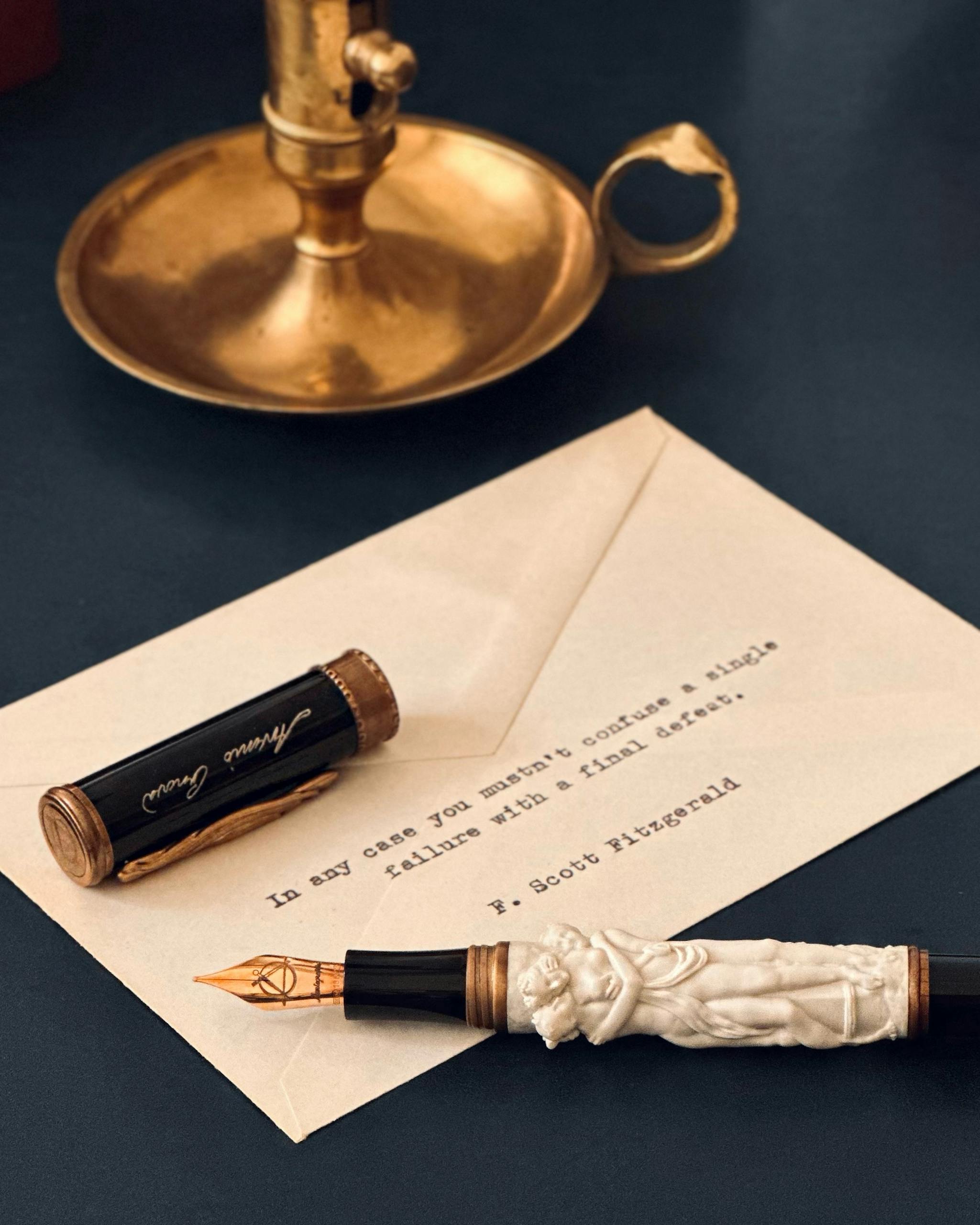 An ornate fountain pen with a quote-adorned letter on a vintage desk.